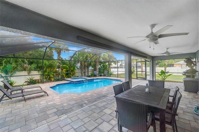 view of pool with a lanai, ceiling fan, a patio, and an in ground hot tub