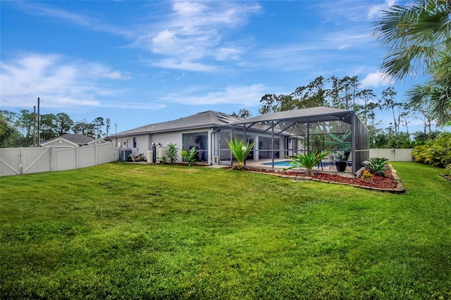 rear view of house with a fenced in pool, glass enclosure, and a lawn