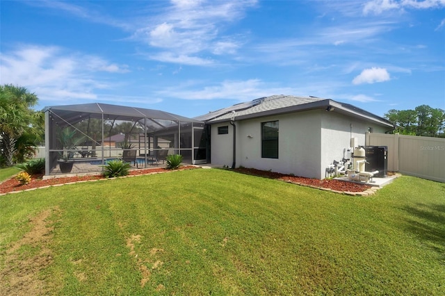 rear view of property with a lawn, a lanai, and a pool