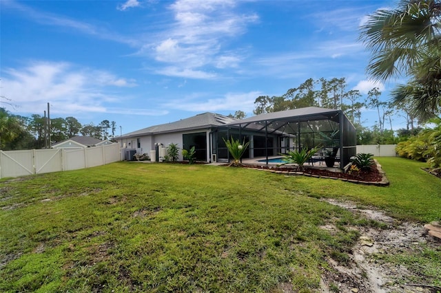 rear view of house featuring a fenced in pool, glass enclosure, and a lawn