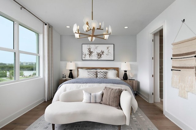 bedroom featuring wood-type flooring, multiple windows, and an inviting chandelier