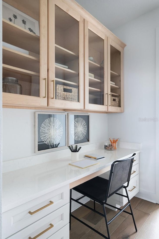 home office with wood-type flooring and built in desk