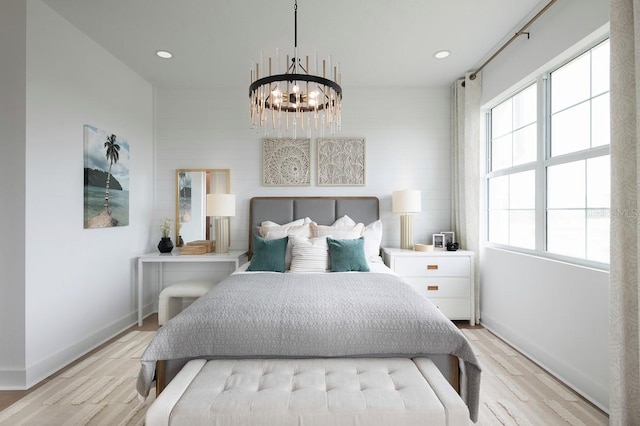 bedroom with light wood-type flooring and an inviting chandelier