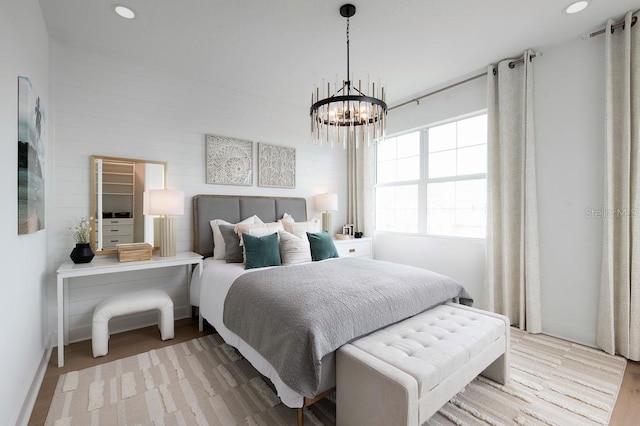 bedroom with light hardwood / wood-style floors and a notable chandelier