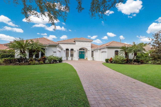 mediterranean / spanish home with a garage, a front yard, and french doors