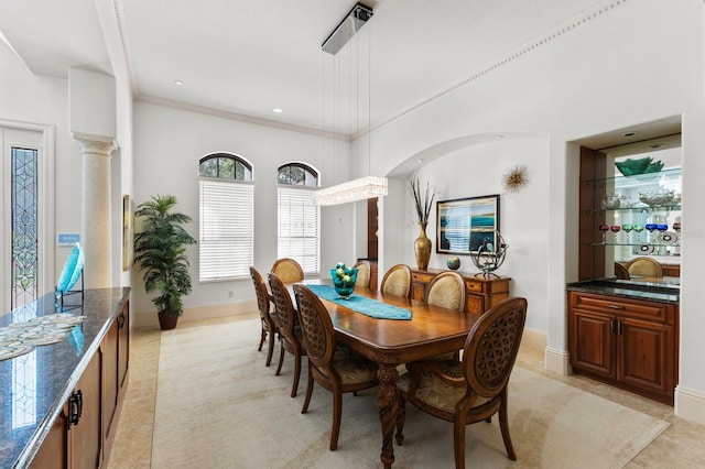 dining space featuring decorative columns and ornamental molding