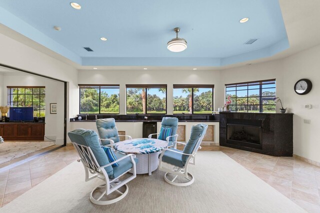 interior space with a raised ceiling and a fireplace