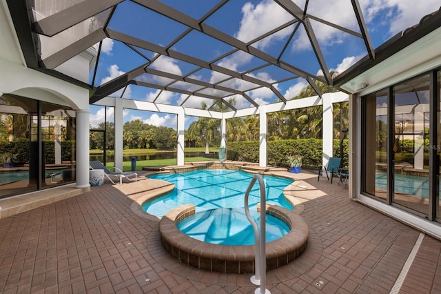 view of pool with a lanai, an in ground hot tub, and a patio