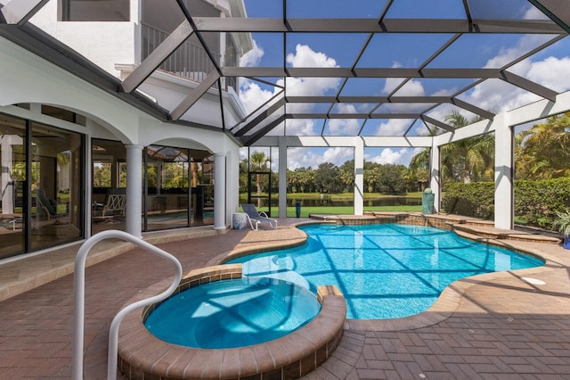 view of pool featuring a patio area, a lanai, and an in ground hot tub