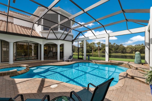 view of pool with glass enclosure, an in ground hot tub, a patio area, and a water view