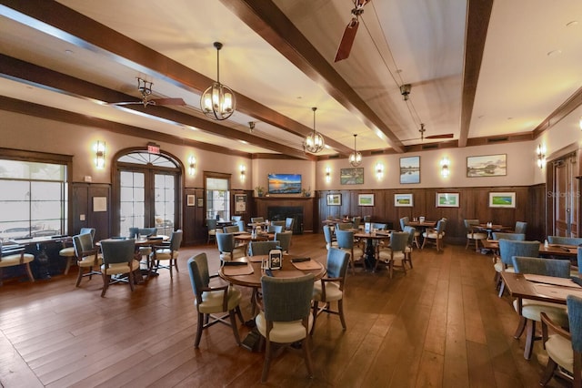 dining area featuring beam ceiling, ceiling fan with notable chandelier, and dark hardwood / wood-style floors