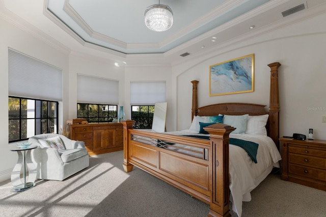 bedroom with light colored carpet, ornamental molding, and a tray ceiling