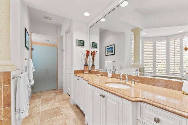 bathroom featuring tile patterned floors, vanity, and ornate columns