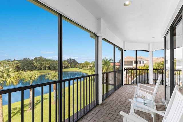 sunroom featuring a water view