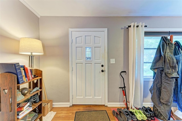 foyer with light hardwood / wood-style floors and crown molding