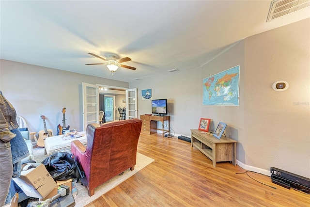 living room with ceiling fan and light hardwood / wood-style floors