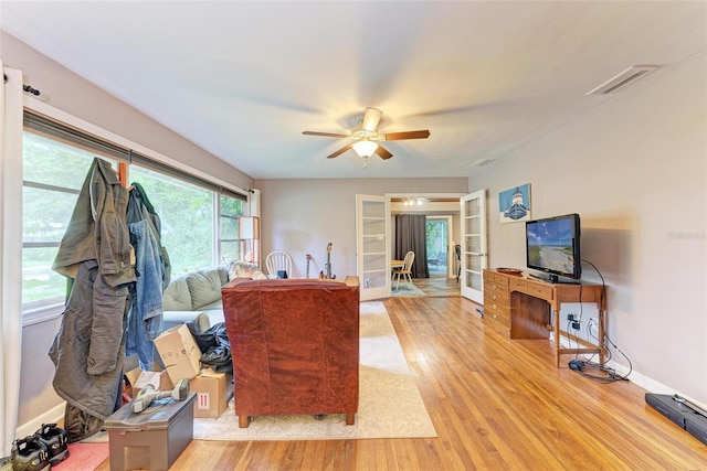 living room featuring light hardwood / wood-style flooring and ceiling fan