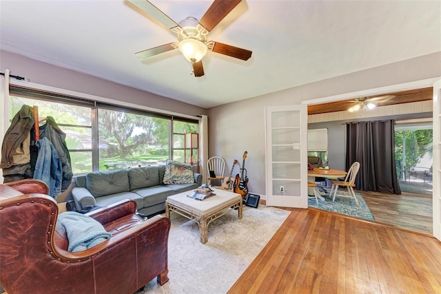 living room featuring a healthy amount of sunlight, ceiling fan, and hardwood / wood-style flooring