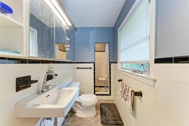 bathroom featuring sink, tile walls, and toilet