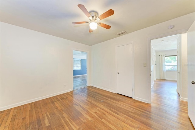 empty room with ceiling fan and light hardwood / wood-style floors