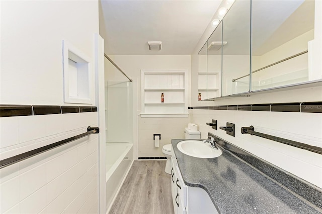 full bathroom featuring tile walls, shower / washtub combination, vanity, wood-type flooring, and toilet