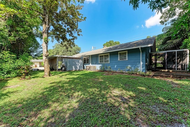 back of property with a sunroom and a yard