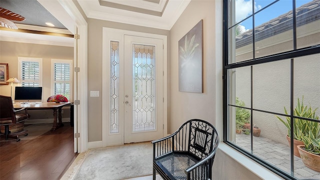 foyer with hardwood / wood-style flooring, crown molding, and a healthy amount of sunlight