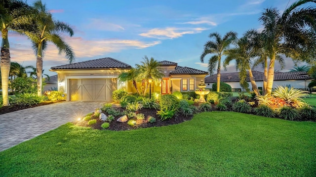 mediterranean / spanish-style house with a lawn and a garage