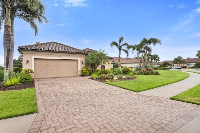 12663 Fontana Loop, Bradenton, FL 34211 - mediterranean / spanish-style home featuring a front yard, stucco siding, decorative driveway, and a garage
