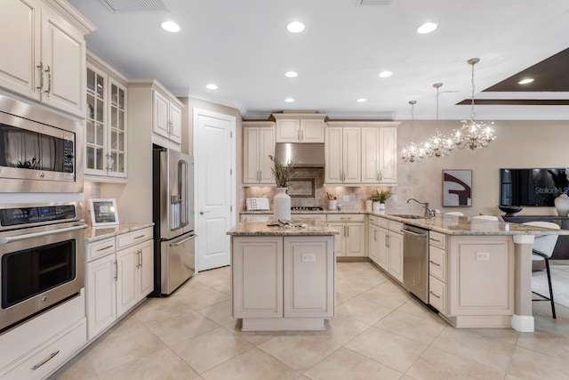 12663 Fontana Loop, Bradenton, FL 34211 - kitchen featuring appliances with stainless steel finishes, a peninsula, a breakfast bar area, tasteful backsplash, and cream cabinetry