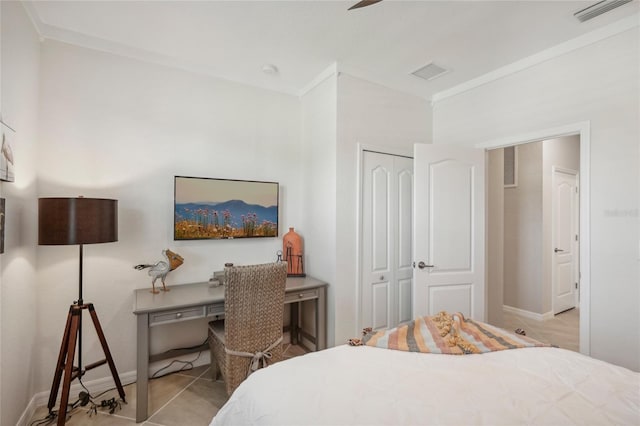 bedroom with ceiling fan, light tile patterned flooring, crown molding, and a closet