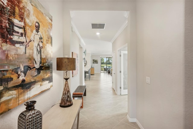 hall with ornamental molding and light tile patterned flooring