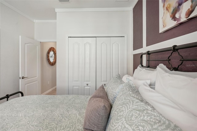 bedroom featuring crown molding and a closet