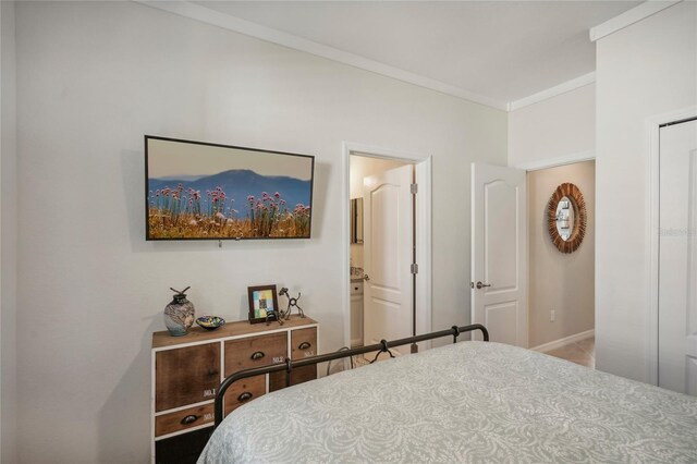 bedroom featuring ensuite bath and crown molding