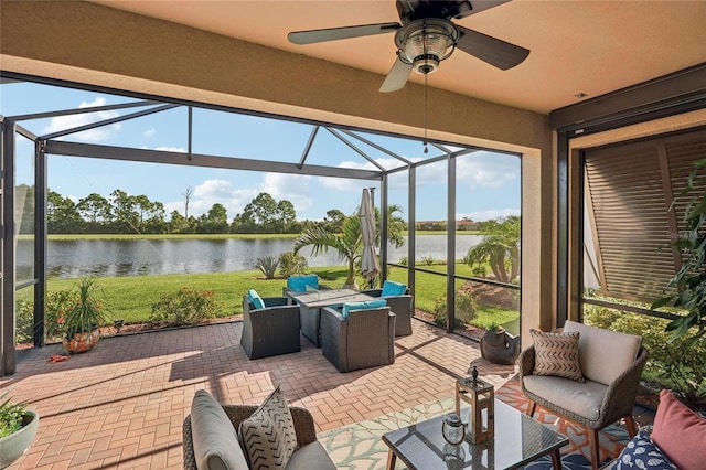 sunroom / solarium featuring ceiling fan and a water view