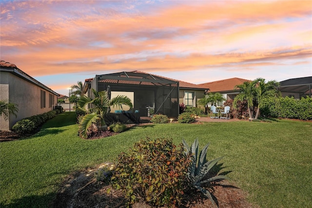 yard at dusk featuring glass enclosure