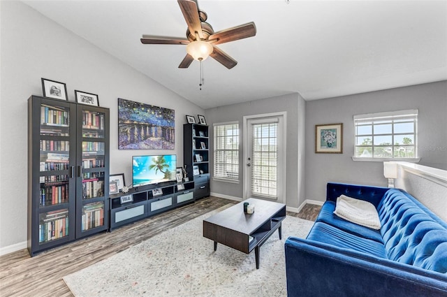 living room with ceiling fan, lofted ceiling, wood finished floors, and a healthy amount of sunlight