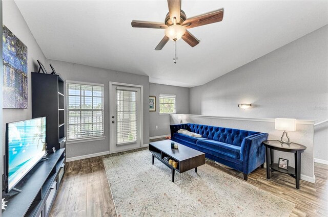 living room with ceiling fan, wood finished floors, and baseboards