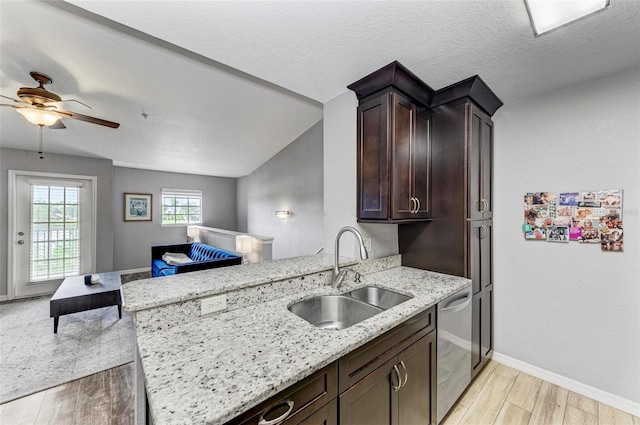 kitchen with light wood-type flooring, a peninsula, a ceiling fan, dishwasher, and a sink