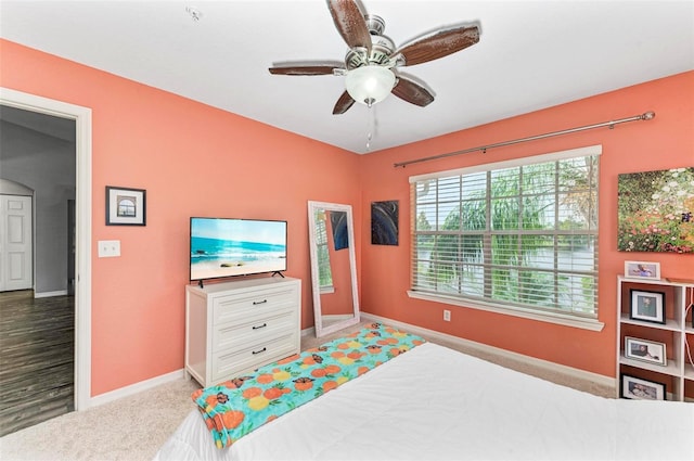 carpeted bedroom with baseboards and a ceiling fan
