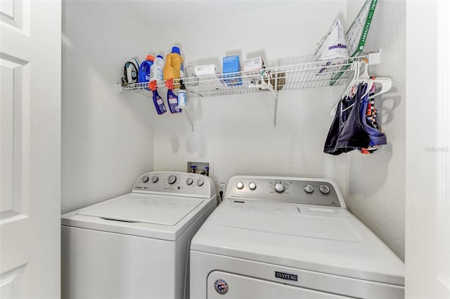 clothes washing area featuring washer and clothes dryer and laundry area