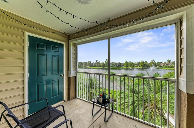 sunroom featuring a water view