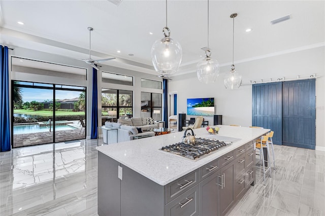 kitchen with light stone countertops, decorative light fixtures, a kitchen bar, and a kitchen island