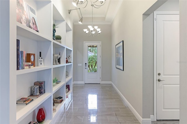 entryway featuring rail lighting, a chandelier, and crown molding