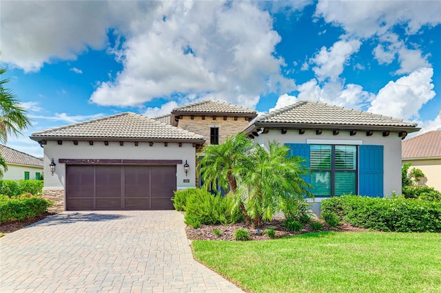 mediterranean / spanish-style home with a garage and a front lawn