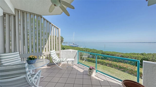 balcony featuring a water view and ceiling fan