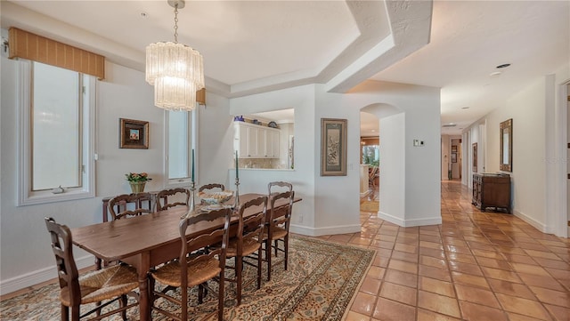 tiled dining space featuring a notable chandelier