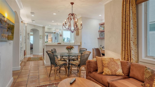 dining room featuring a notable chandelier, light tile patterned flooring, and crown molding