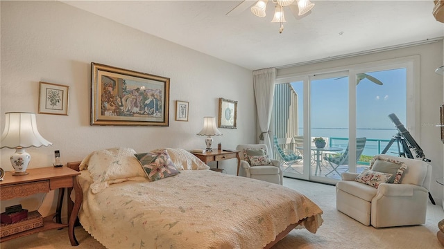 carpeted bedroom with access to outside, a water view, and ceiling fan