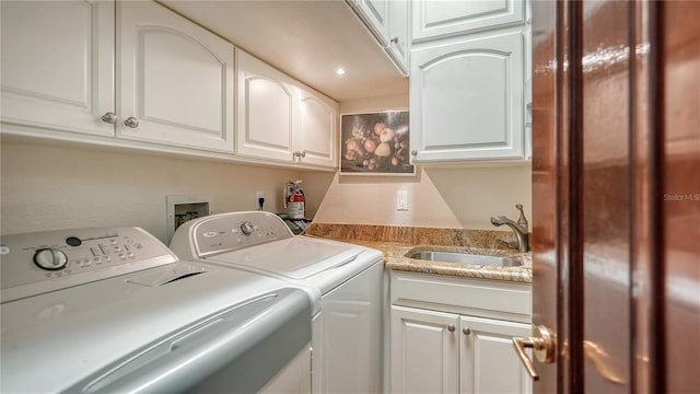 laundry room featuring cabinets, sink, and separate washer and dryer